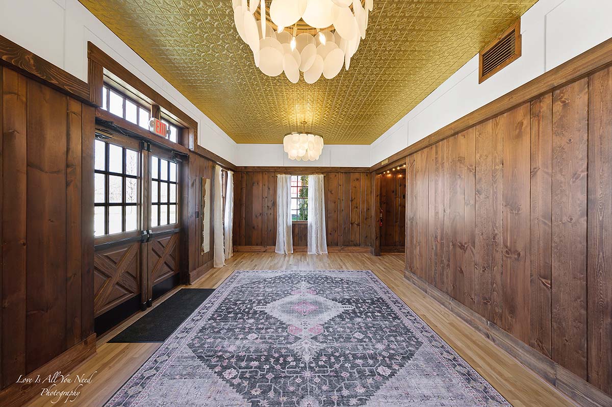 Grand Ballroom set with round tables and lantern chandeliers under exposed wood beams