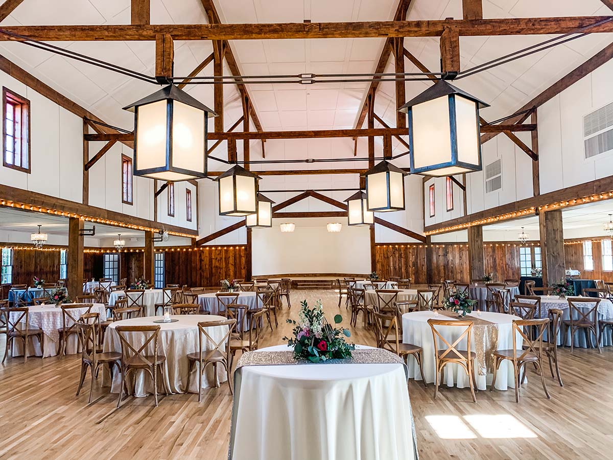 The Grand Ballroom filled with round reception tables, cross-back chairs, and lantern chandeliers